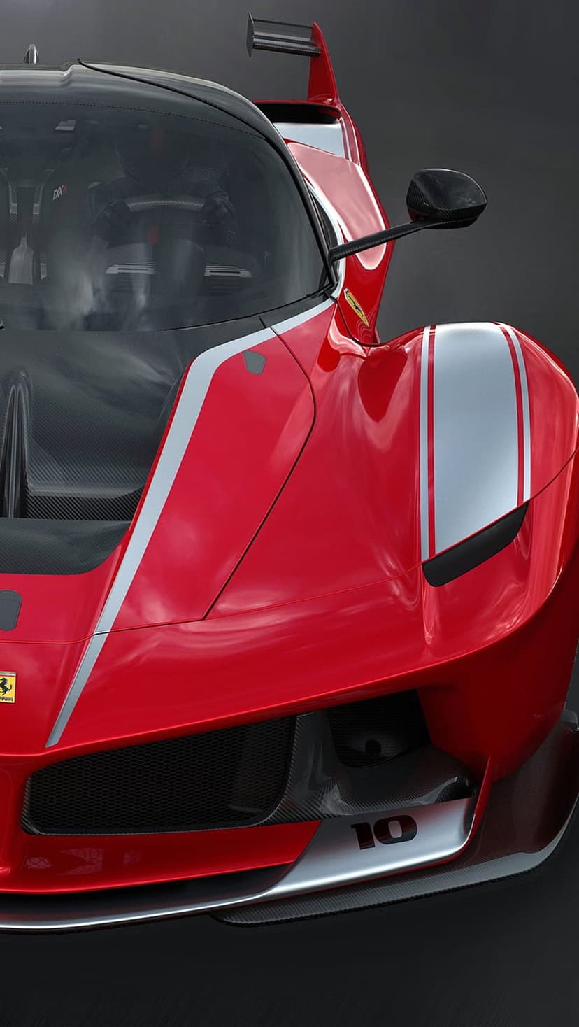 Ferrari FXX K Evo race car features silver stripes and aggressive carbon fiber splitters in a front-facing shot.