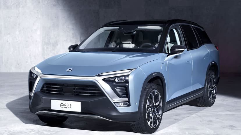 Light blue NIO ES8 electric SUV parked in a gray studio with split headlights and a black panoramic roof.