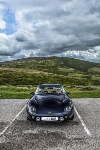 Dark TVR car parked with scenic mountain backdrop