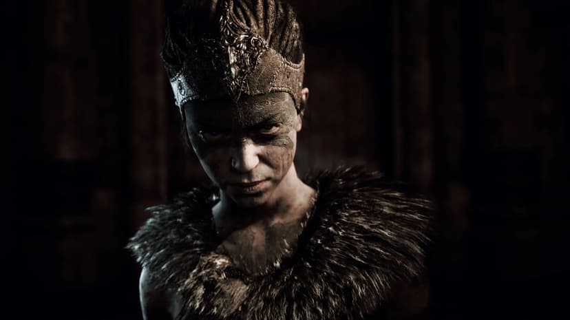Fierce warrior woman with dark war paint and ornate silver crown in dramatic high-contrast lighting.