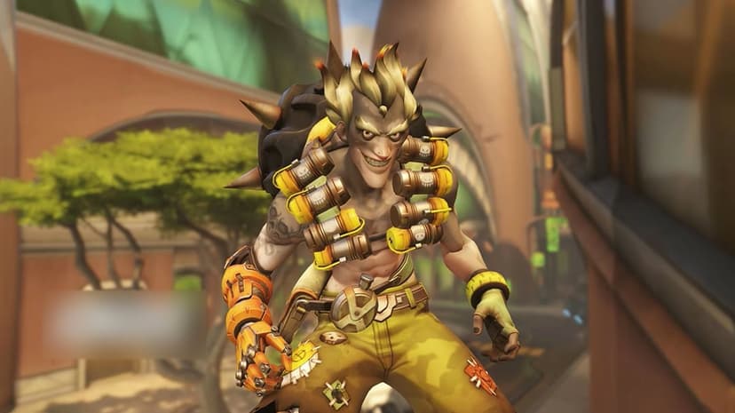 Junkrat from Overwatch grins while wearing explosive gear and a mechanical arm in a sunlit urban city setting.