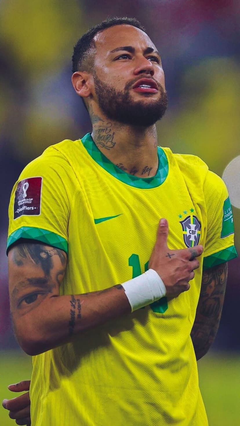 Neymar Jr wearing a yellow Brazil jersey with his right hand over his heart during a national anthem.