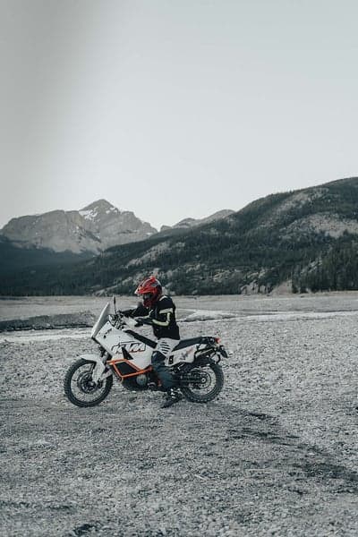 Motorcyclist in Red Helmet on KTM Adventure Bike in Rocky Terrain
