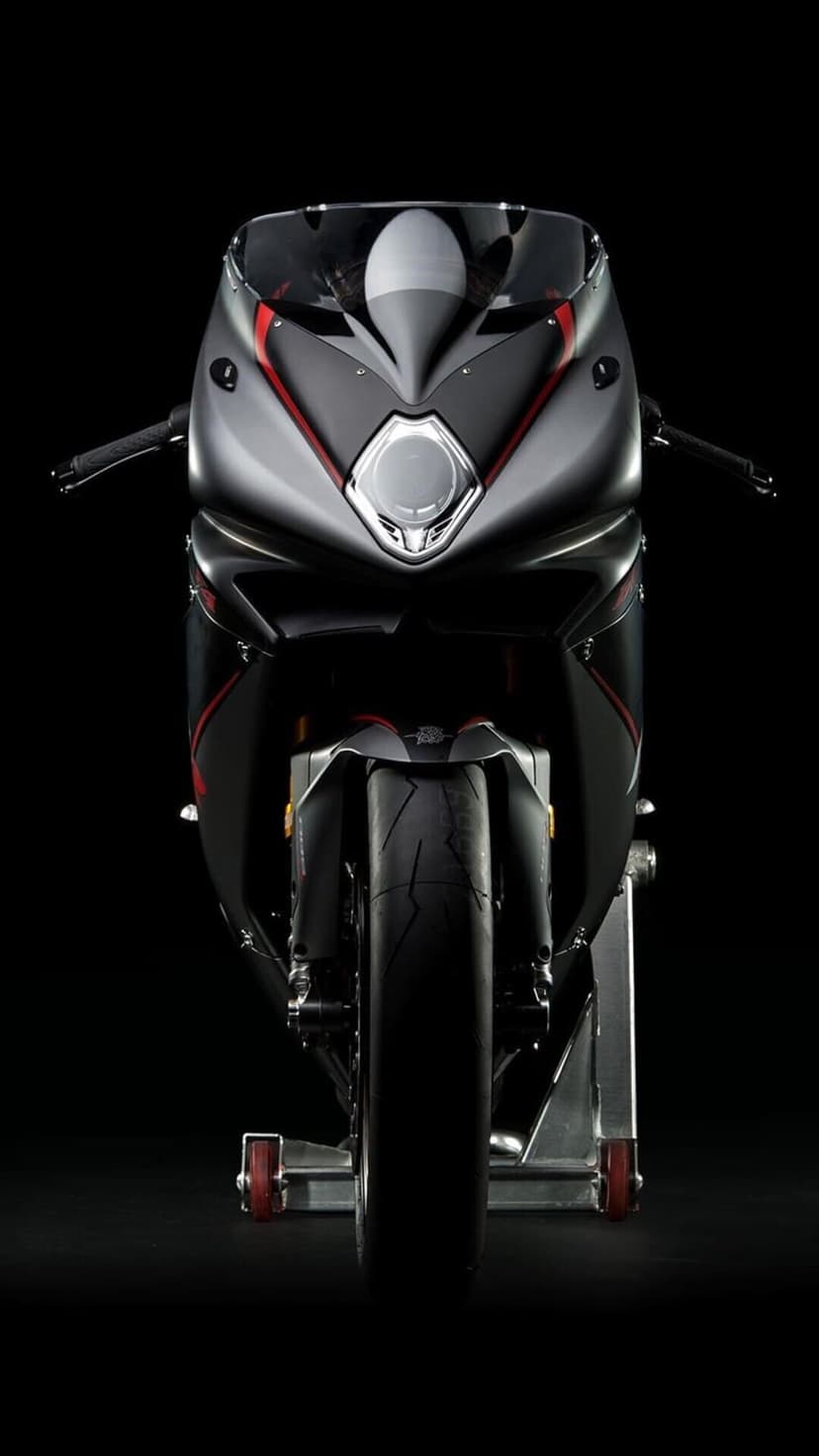 Front view of a matte grey sportbike with a diamond headlight and red accents on a black background.