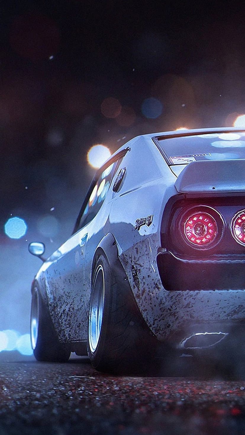 Modified Nissan Skyline GT-R with muddy bodywork and glowing red taillights parked on a city street at night.