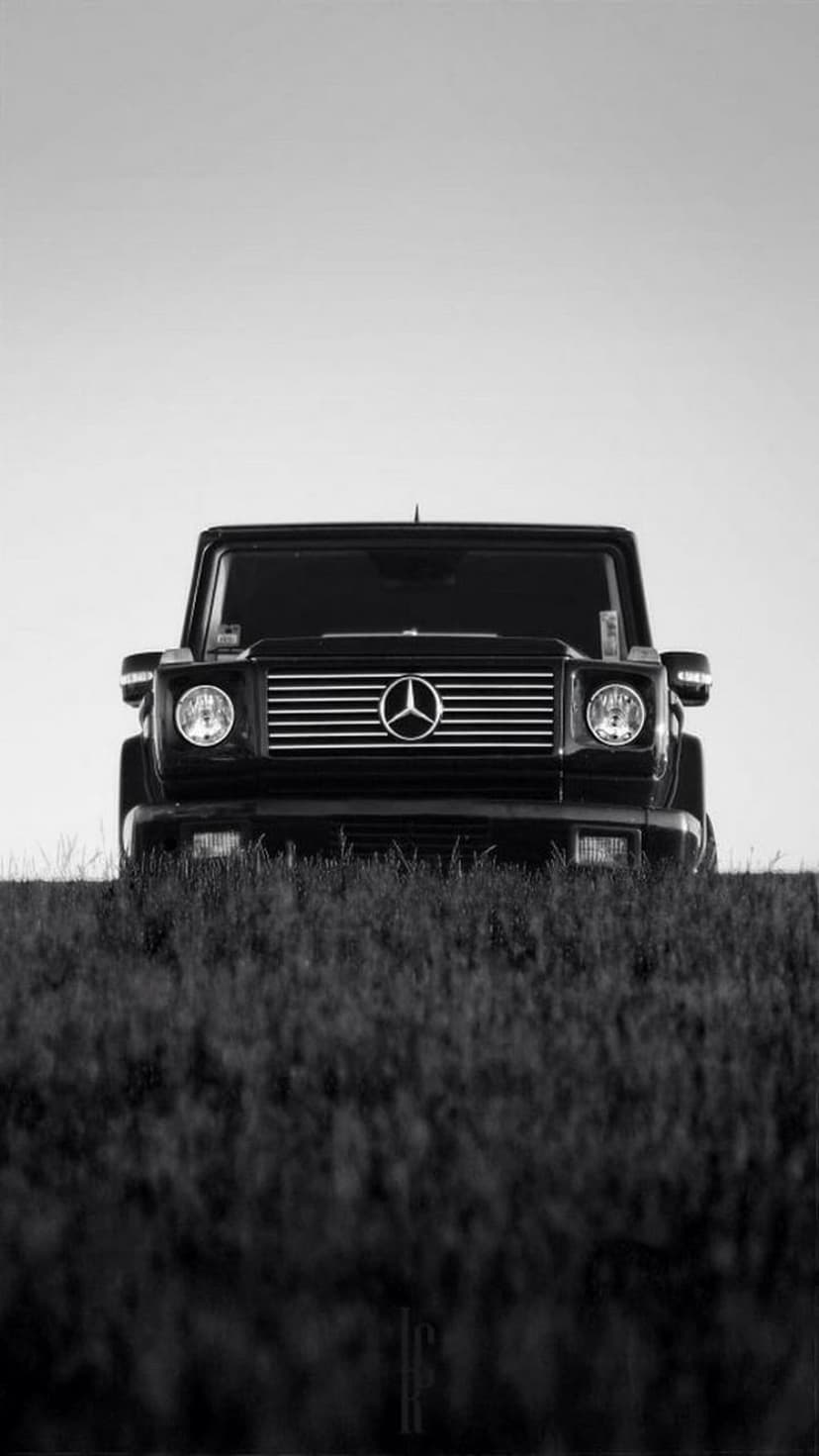 Mercedes-Benz G-Wagon SUV parked in a grassy field, captured in high-contrast black and white monochrome tones.