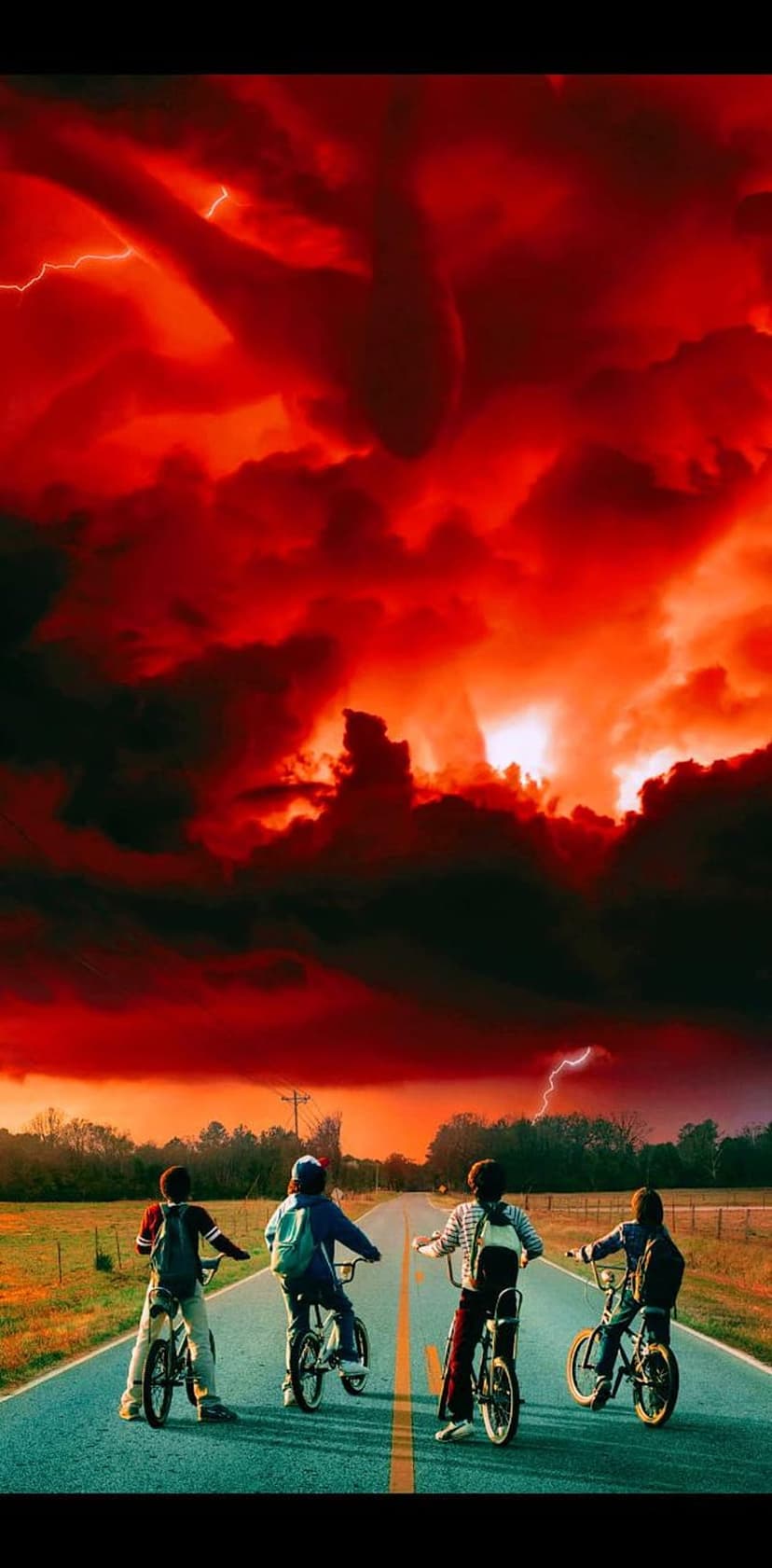 Four children on bicycles stare at a giant multi-limbed shadow creature in a dark sky with red lightning.
