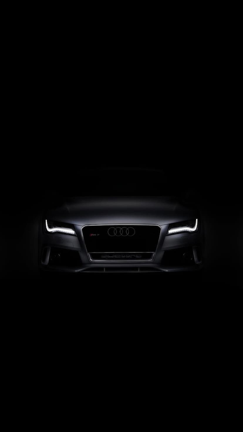 Audi RS7 front grille with glowing white LED headlights centered against a solid black background.