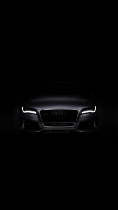 Dark Audi RS7 Front View with Glowing Headlights