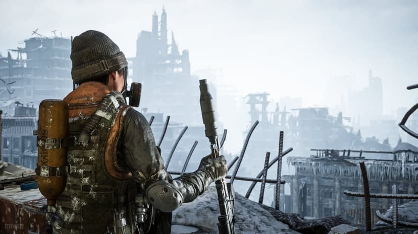 Survivor in survival gear holds a rifle while looking over a foggy, ruined city covered in snow and ice.