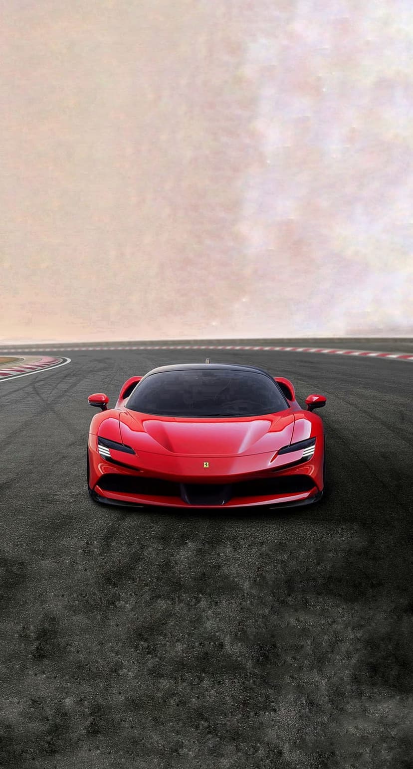 Red Ferrari SF90 Stradale parked head-on on a dark asphalt racing circuit under a bright, hazy sky.