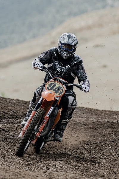 Motocross Rider Races Dirt Bike on Track