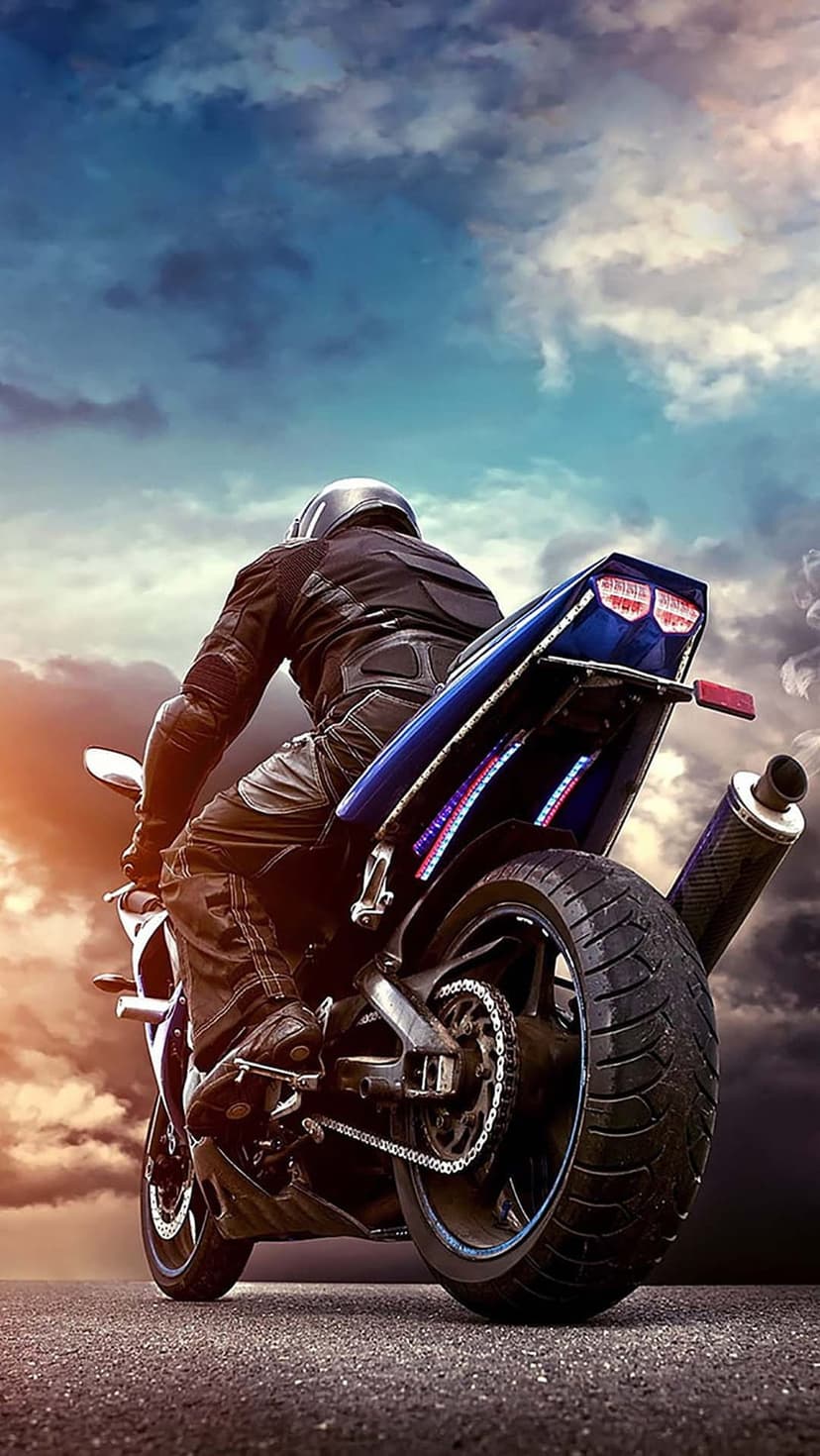 Motorcyclist on a blue bike faces a dramatic sunset with heavy orange-lit clouds under a twilight sky.