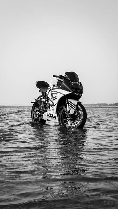 KTM Sports Motorcycle in Shallow Ocean Water Mobile Wallpaper