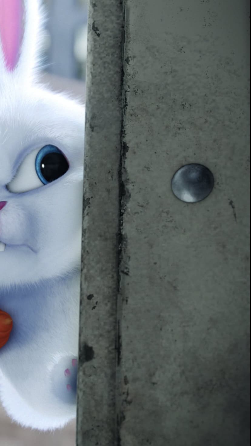 White bunny with bright blue eyes and pink ears peeks around a gray metal corner holding a small orange carrot.