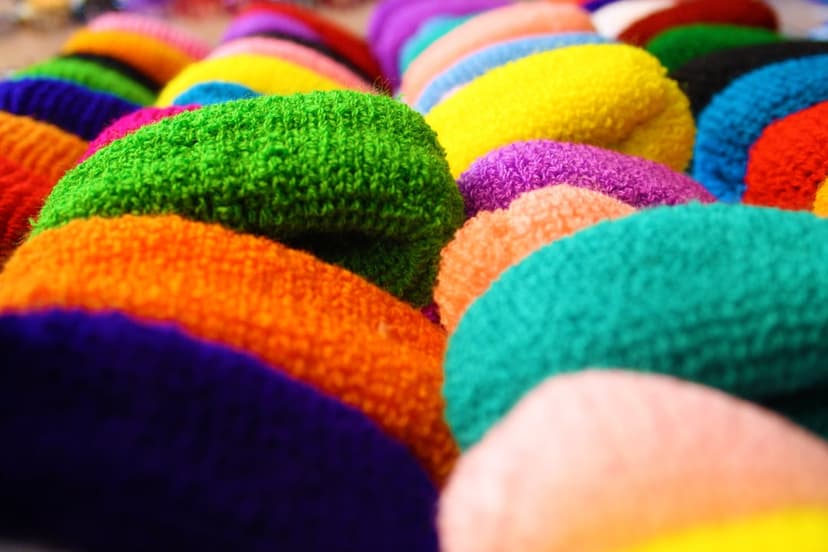 Terrycloth headbands in a rainbow spectrum are arranged in neat rows with a soft, plush textile texture.