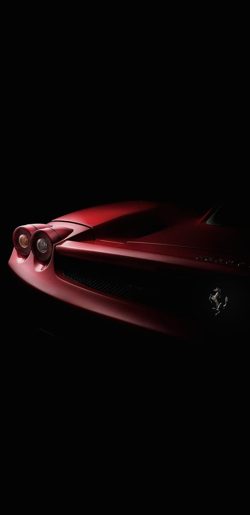 Red Ferrari front end showing headlights and the prancing horse emblem centered on a dark black background.
