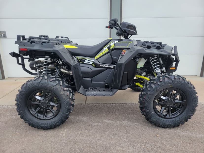 Profile of a black Polaris Sportsman 1000 S ATV with lime green accents and large rugged tires outdoors.