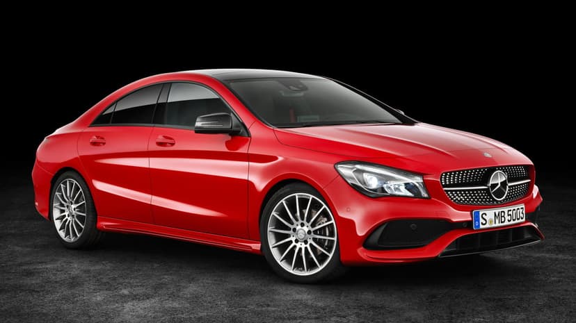 Red Mercedes-Benz CLA sport sedan with silver wheels and LED headlights on a dark studio background.
