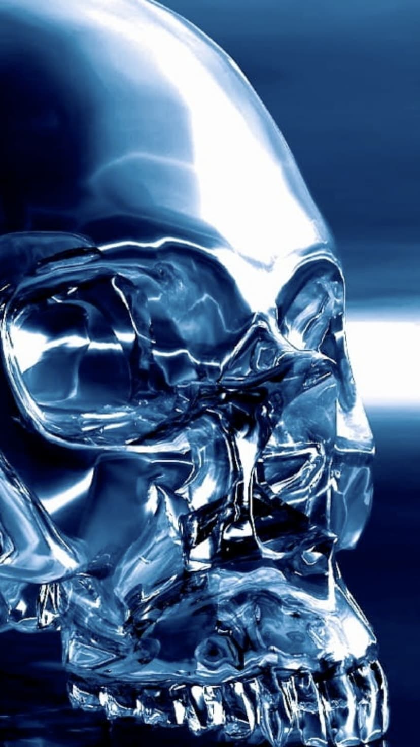 Polished blue skull with frozen crystalline textures and sharp highlights against a blurred dark background.