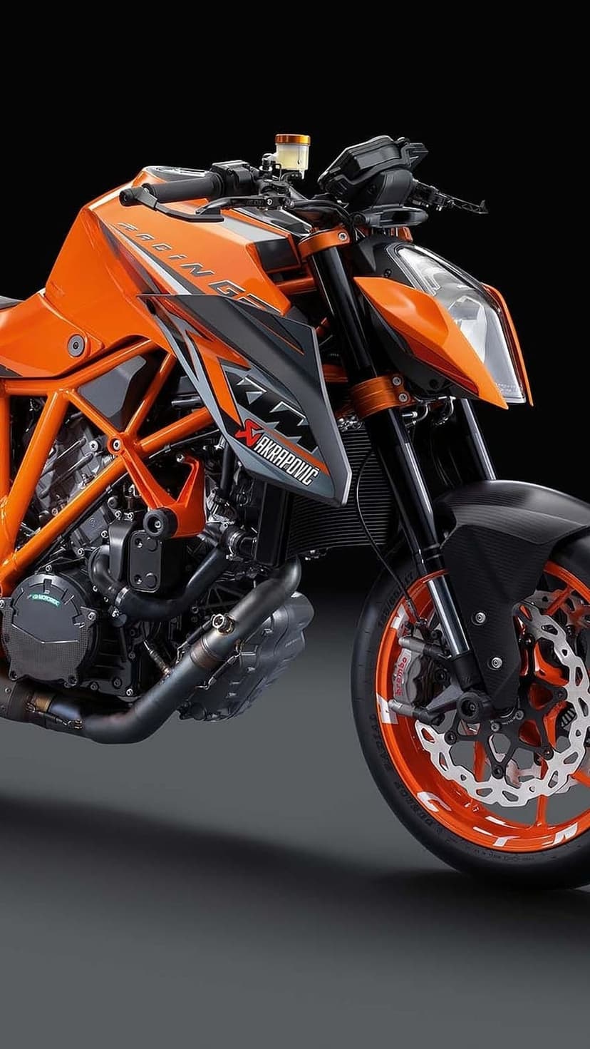 KTM 1290 Super Duke R engine, orange trellis frame, and front wheel disc brake in a close-up mechanical view.