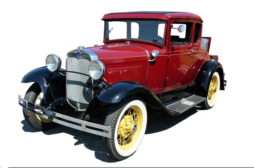 Red Ford Model A coupe with yellow wire wheels and chrome accents parked against a plain white background.