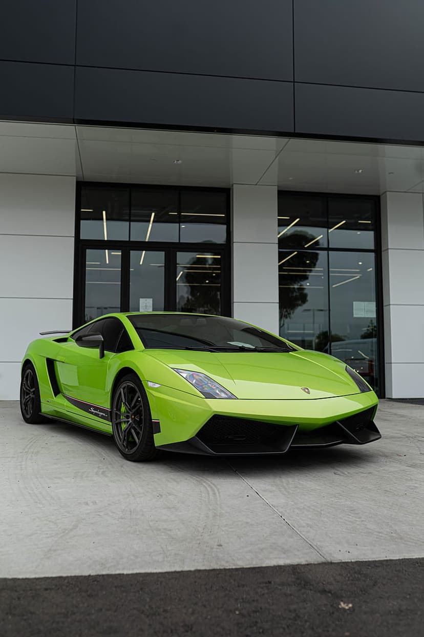 Neon green Lamborghini Gallardo Super Trofeo Stradale parked near a modern glass building in portrait view.