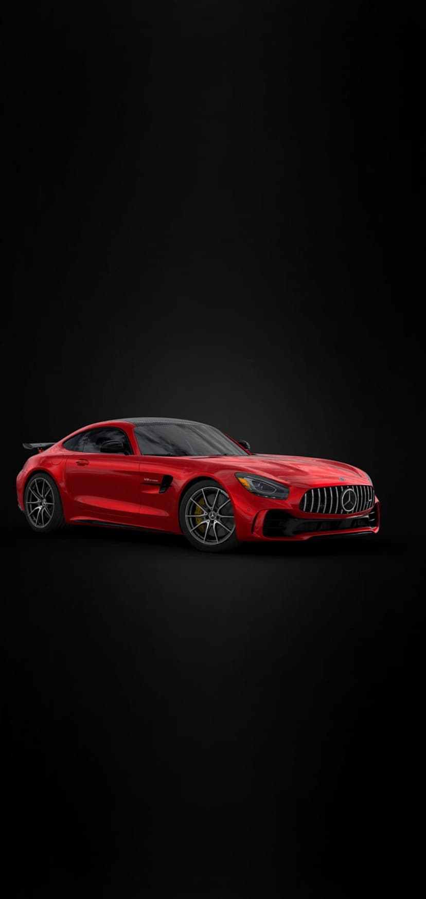 Red Mercedes-AMG GT R sportscar with a large rear spoiler and aggressive grille on a solid black background.