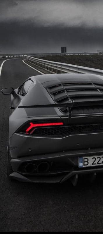 Dark Lamborghini on a Highway Under Stormy Skies