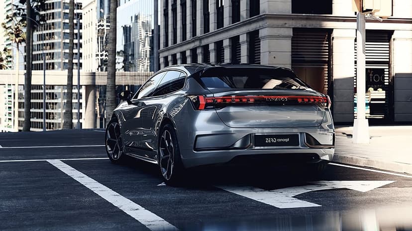 Rear view of a silver electric concept car with a red light bar parked on a sunlit urban asphalt road.