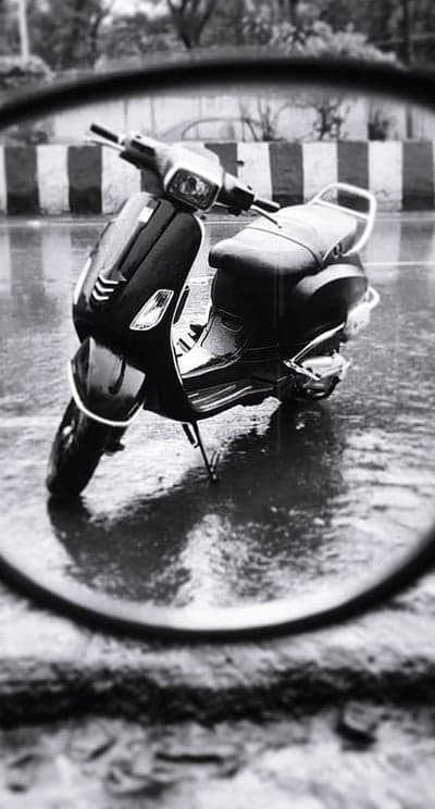 Black and White Scooter Reflecting in Puddle