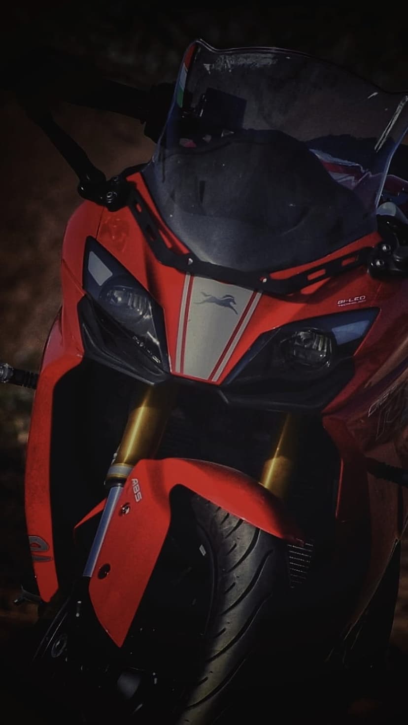 Red TVS Apache RR 310 front fairing with LED headlights, gold USD forks, and racing stripe in moody lighting.
