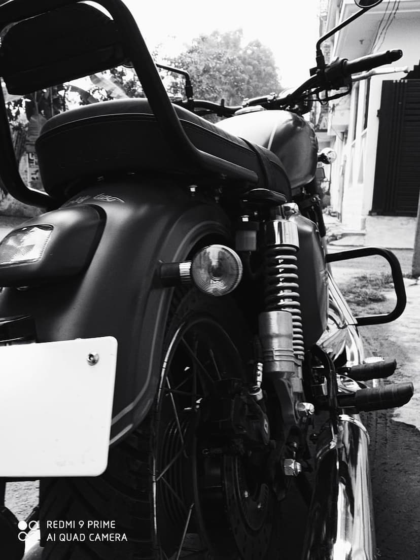 Vintage motorcycle rear wheel and suspension details captured in high-contrast black and white photography.