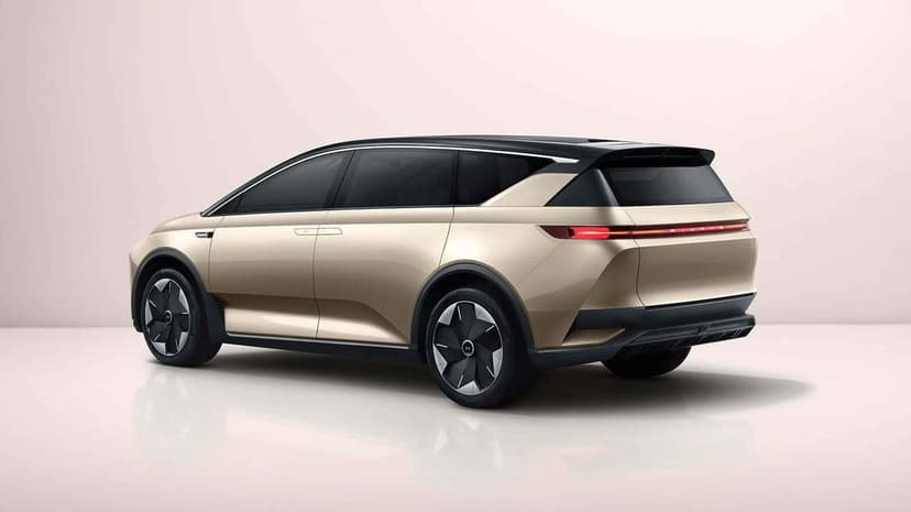 Rear view of a sleek champagne gold electric SUV with slim LED taillights in a minimalist studio setting.