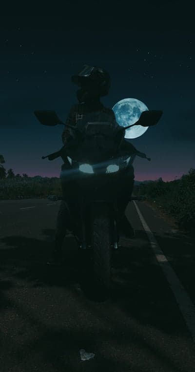 Night Rider Silhouette under Glowing Full Moon Phone Wallpaper