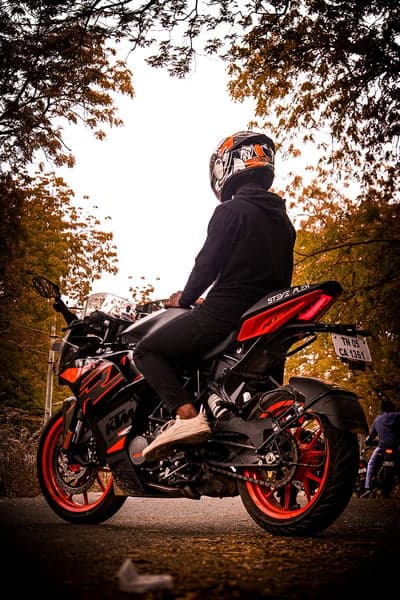 Man on KTM motorcycle with autumn trees background