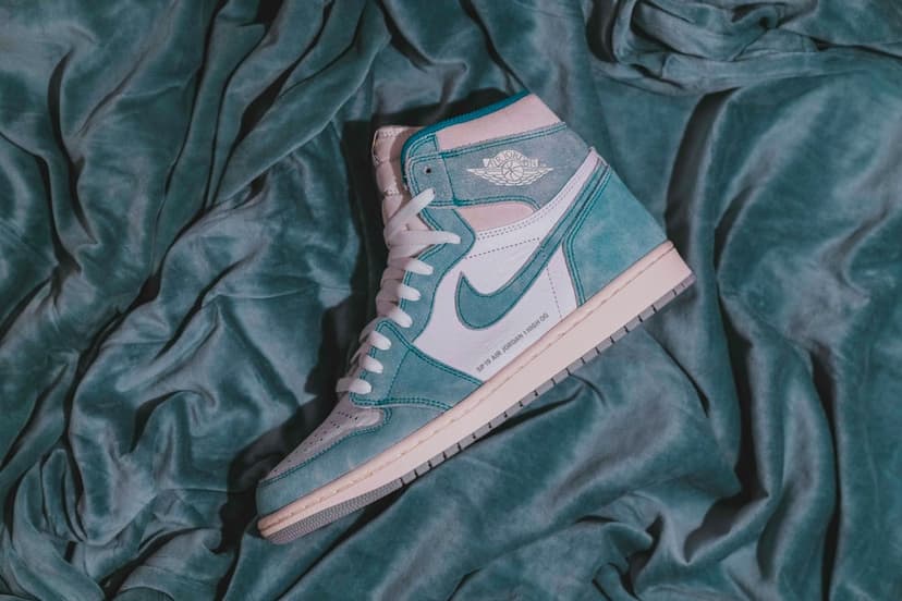 Air Jordan 1 High OG teal and white sneakers showing suede textures, the Nike Swoosh, and a leather high-top frame.
