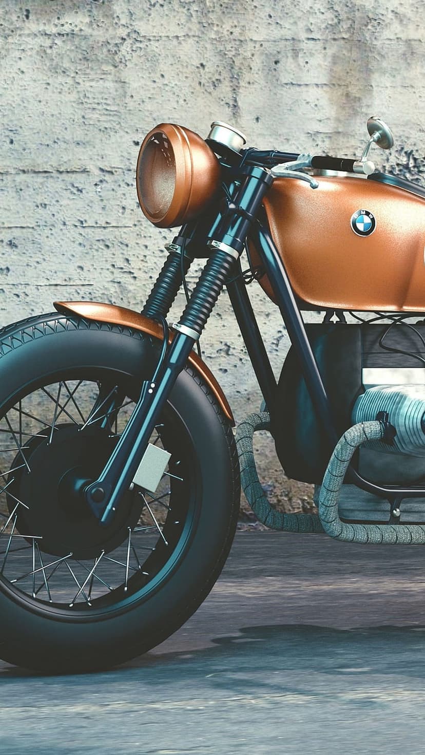 Vintage BMW motorcycle front end with metallic copper tank, round headlight, and spoked wheel against concrete.