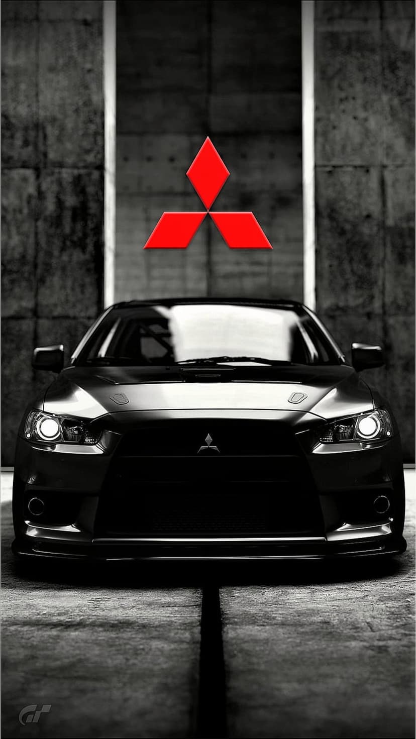 Black Mitsubishi Lancer Evolution parked on concrete with a red diamond logo and dramatic lighting shadows.