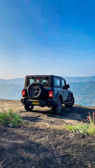 Mahindra Thar on cliff edge with scenic mountain view