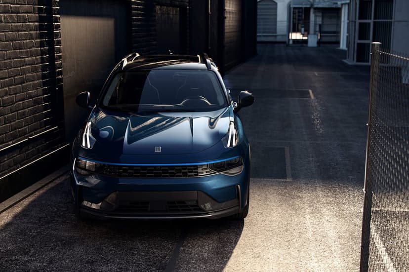 Blue SUV in a dark alleyway between brick walls with dramatic lighting on its front and roof.