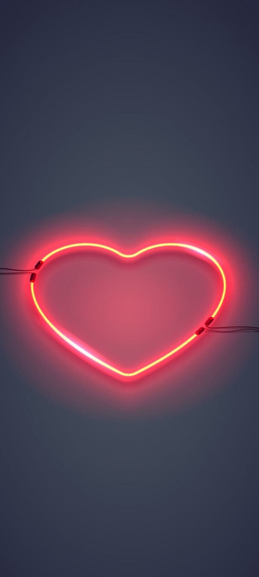 Red neon heart tube glowing with a soft scarlet light against a pitch-black minimalist background.