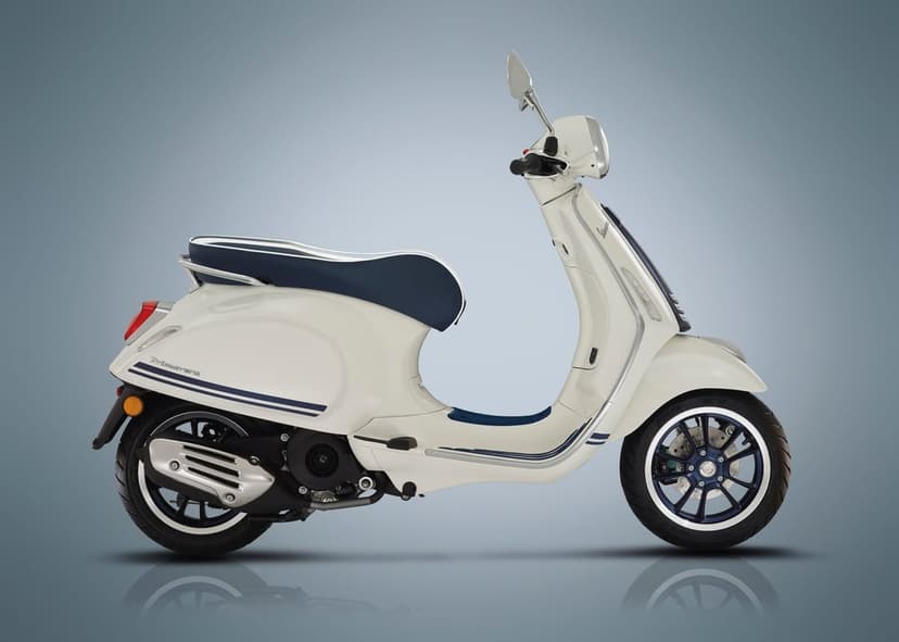 White Vespa Primavera scooter with navy blue accents and wheels on a minimalist gray gradient background.