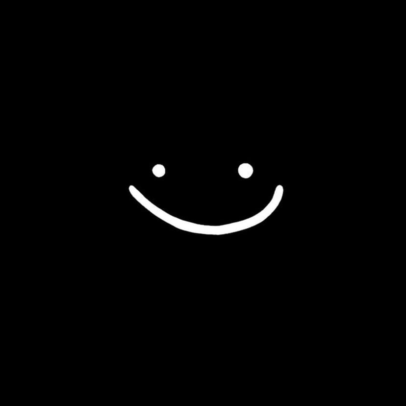 White smiley face featuring circular eyes and a curved smile positioned on a seamless dark black background.