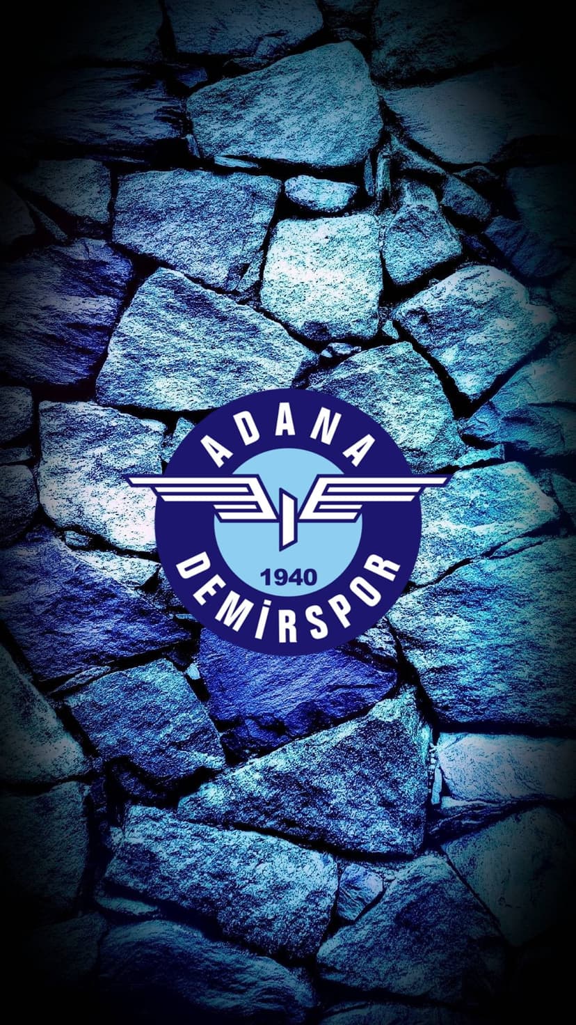 Adana Demirspor club logo with the year 1940 displayed on a dark blue and grey textured masonry stone wall.