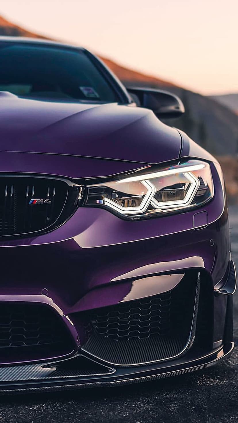 Purple BMW M4 front headlight and kidney grille showing intricate LED details and metallic paint textures.
