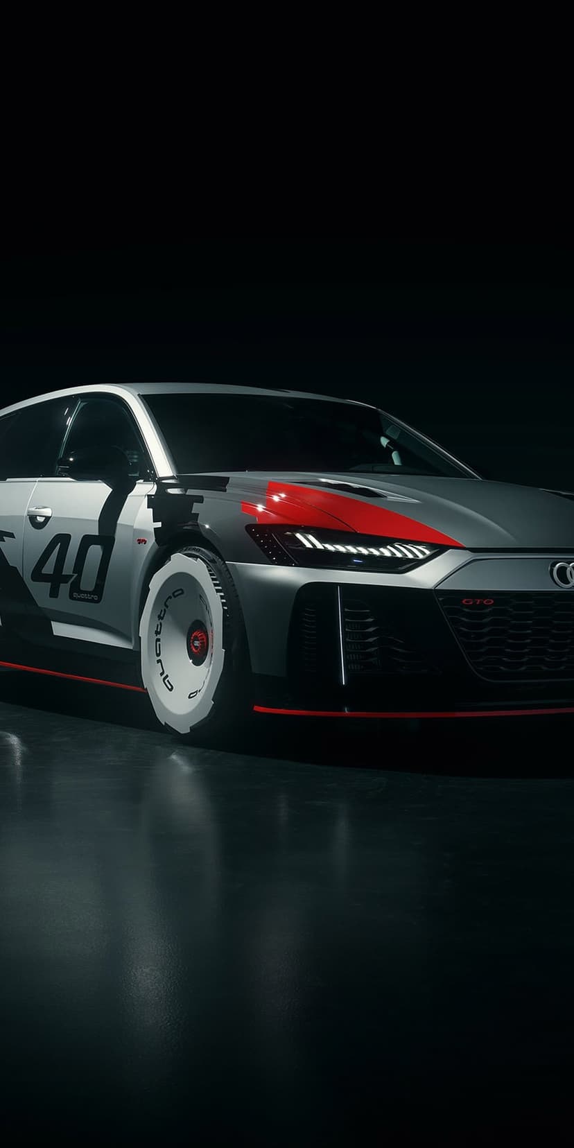 Audi RS 6 GTO concept car with silver racing livery and red accents parked on a dark reflective studio floor.