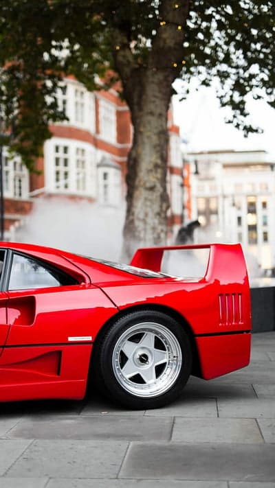 Red Ferrari F40 parked on cobblestone street