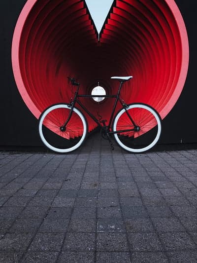 Black bicycle with white wheels in red tunnel