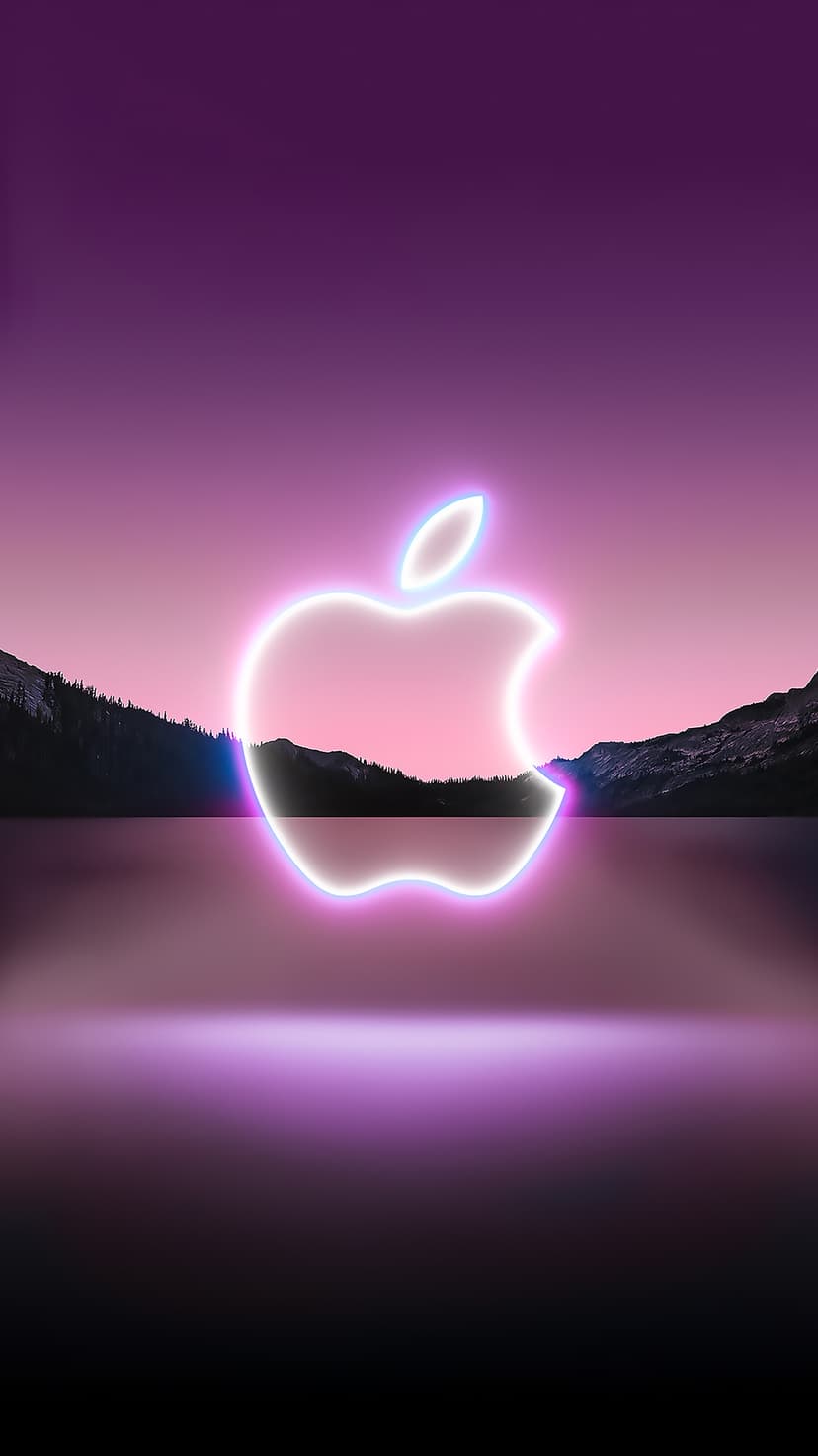 Apple logo in neon pink and blue glows above a reflective lake with dark mountain silhouettes at twilight.